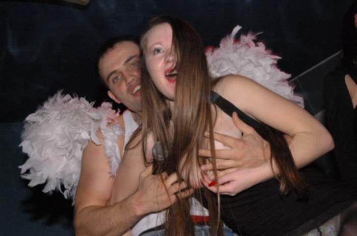 На секс вечеринке ди-джей раздевает рыжую девицу, показывая толпе ее большие сиськи и белые трусики под черными, нейлоновыми колготками