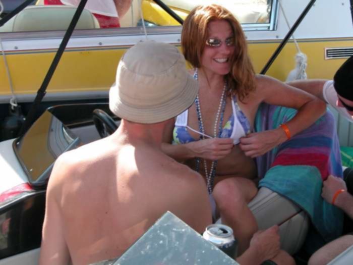 Рыжая шлюшка примеряет белое бикини в лодке на глазах у парней